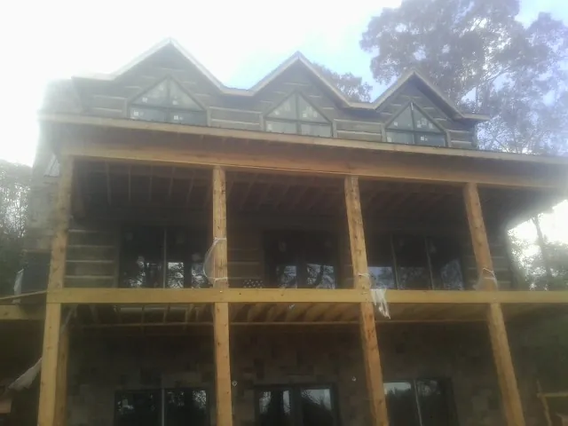 Dormers and porch framing on a large log home under construction — Roof Coating work by our crew in Eastpointe