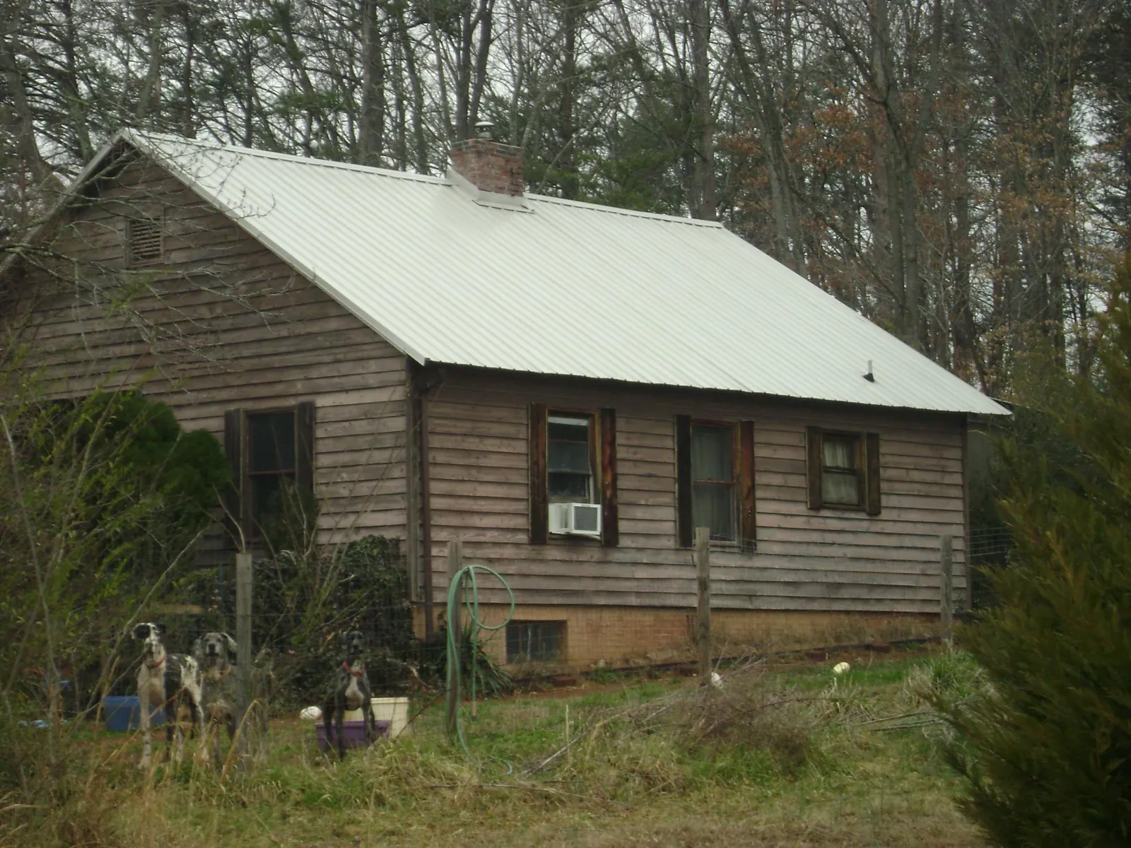 White metal roof on an old wood sided farmhouse, from a Metal Roof Installation job in Eastpointe